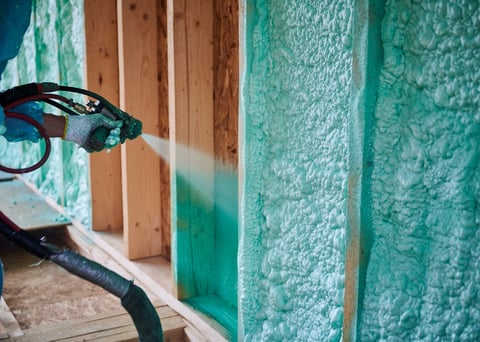 Spray foam insulation applied to walls in a large building interior